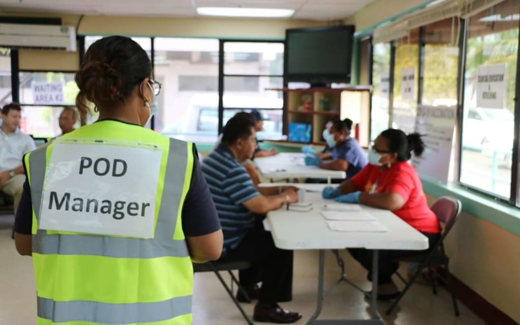 A Ministry of Health official screens people during the first day of coronavirus vaccinations.