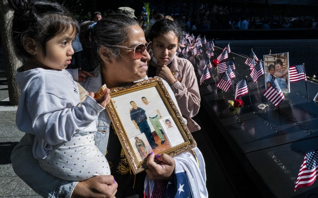 Julia Melendez, holds a photo of her husband Antonio, who died working at Windows on the World Restaurant, at the National 9/11 Memorial during the ceremony commemorating the 20th anniversary of the 9/11 attacks on the World Trade Center, in New York, on September 11, 2021.