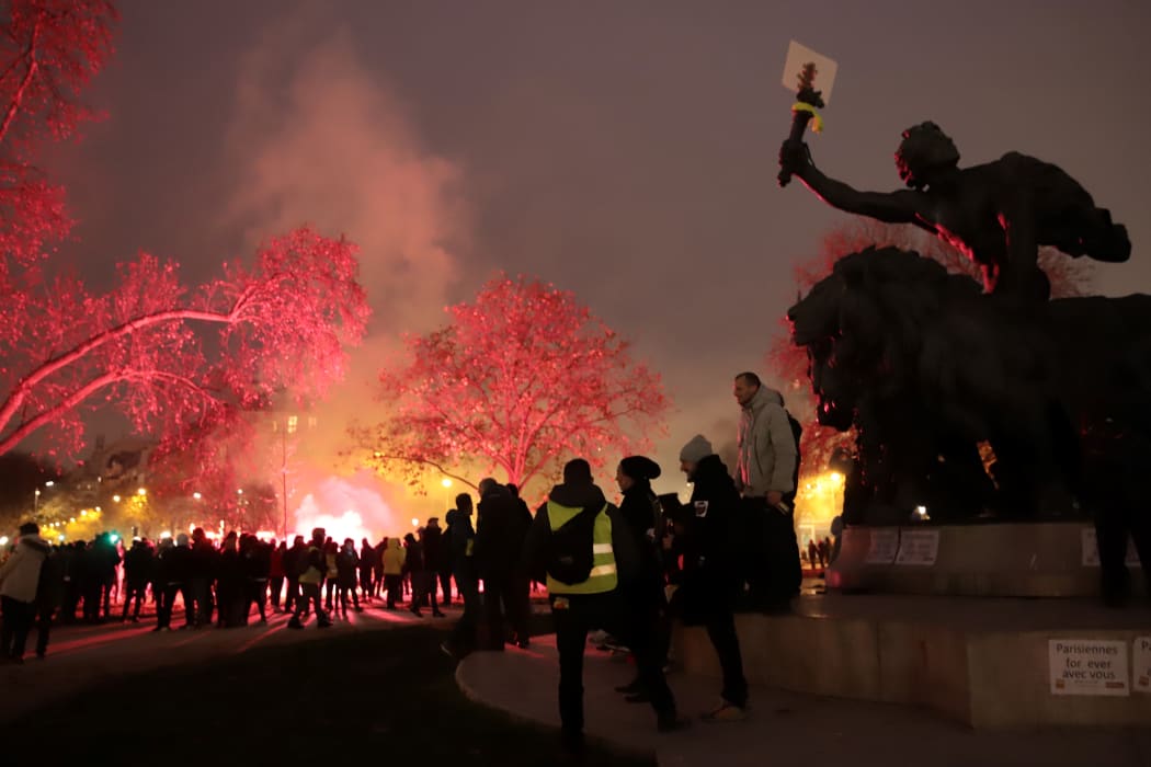 Protestors gather near the "Triomphe de la Republique" statue among flares during a demonstration against the pension overhauls, in Paris, on December 5, 2019 as part of a nationwide strike.