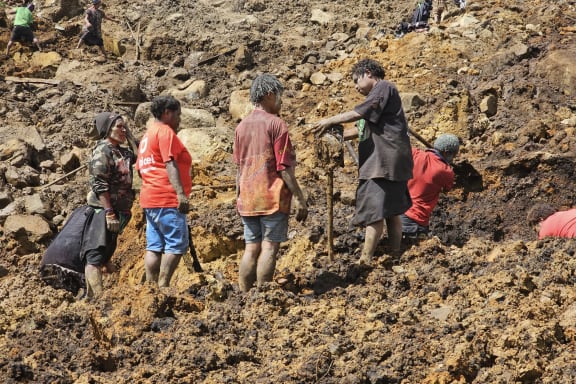 Locals dig during search and rescue efforts at the site of a landslide at Yambali village in the region of Maip Mulitaka in Papua New Guinea's Enga Province on May 30, 2024. Survivors of a deadly Papua New Guinea landslide face a "significant risk of disease outbreak" and are yet to receive sufficient food and clean water supplies, a United Nations agency said on May 30. Six days after a mountainside community was buried in a sea of soil, boulders and debris, the United Nations' migration agency said water sources had become tainted and the risk of disease was soaring. (Photo by Emmanuel Eralia / AFP)