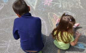 Boy and girl drawing with chalk home orphan child dream. children paint on the pavement. happy childhood on the street. isolation out.