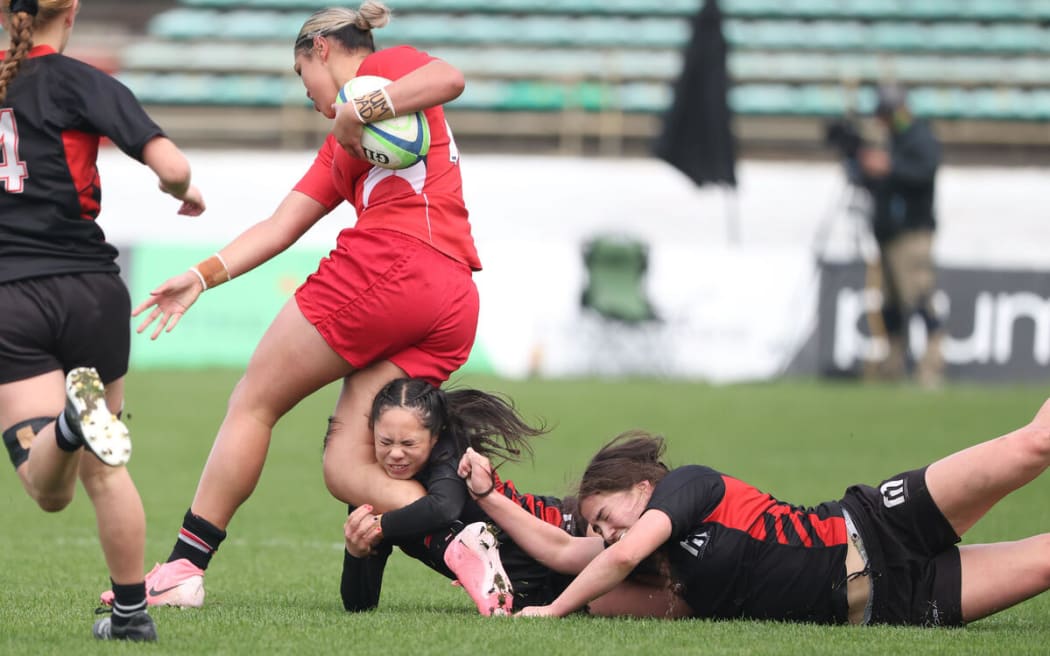 Asha Taumoepeau-Williams of Howick College is tackled by Araia Keighley-Rein of Manukura.
