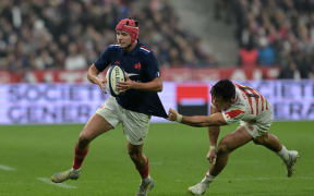 France's wing Louis Bielle-Biarrey attempts to break away from Japan's wing Tomoki Osada during the Autumn Nations Series International rugby union test match between France and Japan at the Stade de France in Saint-Denis, suburb of Paris, on November 9, 2024. (Photo by Bertrand GUAY / AFP)