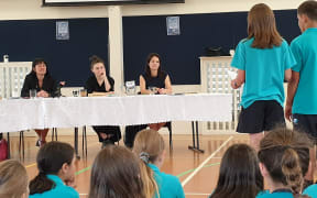 Labour Party MP Marja Lubeck, Green Party MP Chloe Swarbrick and National MP Erica Stanford listen earnestly to Long Bay Primary School year six students' petition.