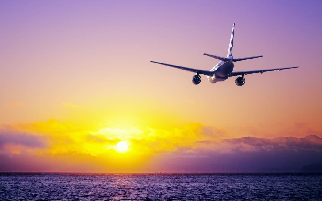 big airplane in the sky flying over ocean