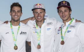 Erik Heil (centre) stands on the podium at the Olympic test regatta next to Blair Tuke (left) and Thomas Plößel.