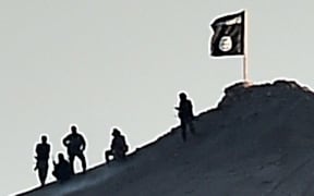 An Islamic State flag on a hill by Kobane - another was on a building on the eastern side of the Syrian border  town.