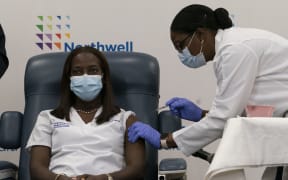 Sandra Lindsay, left, a nurse at Long Island Jewish Medical Center, is inoculated with the Covid-19 vaccine by Dr. Michelle Chester, December 14, 2020 in the Queens borough of New York City.