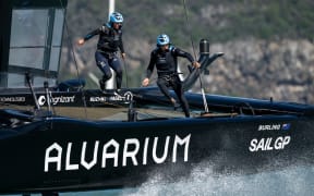 Liv Mackay, strategist of New Zealand SailGP Team and Blair Tuke, Co-CEO and wing trimmer of New Zealand SailGP Team run across the boat during racing on Lyttelton Harbour, 2023.