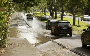 Traffic queued as cars drive through the remaining floodwater on St Lukes Road on Saturday morning.