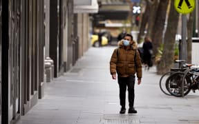 A man walks down the normally busy shopping precinct of Collins Street in Melbourne on July 22, 2020