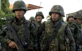 Soldiers stand guard in Bangkok after the military announced it had taken control.