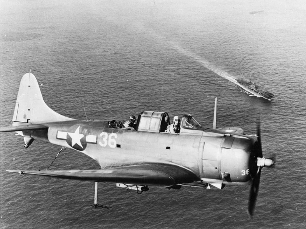 An SBD Dauntless flying over the USS Enterprise.