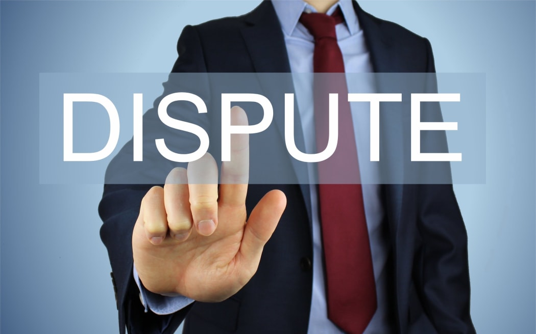 Man in suit pointing at dispute sign