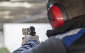 Shooting with Gun at Target in Shooting Range. Man Practicing Fire Pistol Shooting.