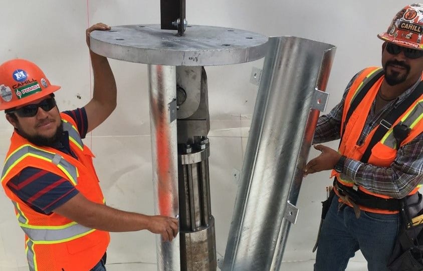 Workers installing an earthquake energy absorbing damper within the foundation of Casa Adelante. It was developed by Professor Geoffrey Rodgers from the University of Canterbury.