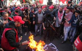Protesters burn an effigy of US President Donald Trump as Palestinian Popular Front for the Liberation of Palestine supporters rally in Gaza City to protest against US President Donald Trump's decision to recognize Jerusalem as Israel's capital.