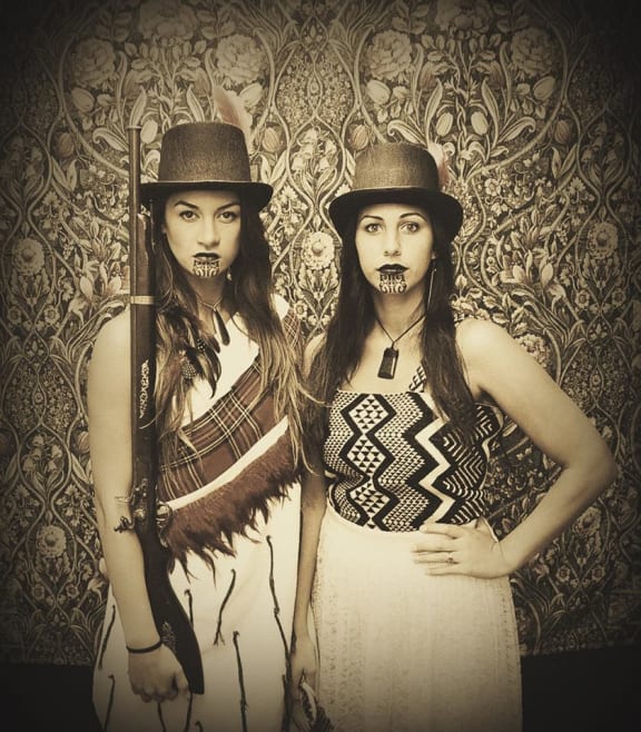 Taaniko Nordstrom and Vienna Nordstrom. both are in traditional Maori dress and one is carrying a rifle