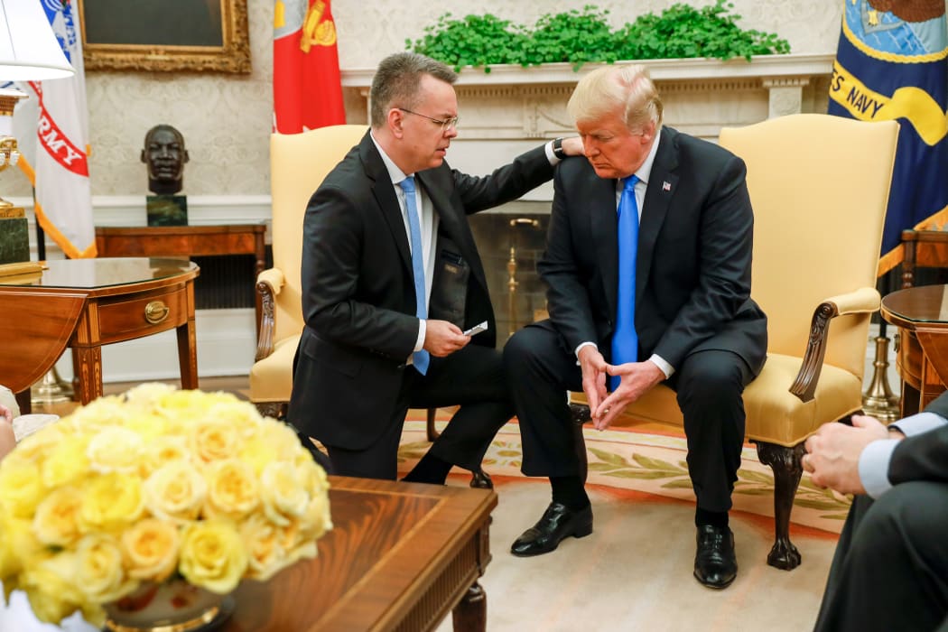 Freed American pastor Andrew Brunson (L) prays for US President Donald Trump at the White House in Washington.
