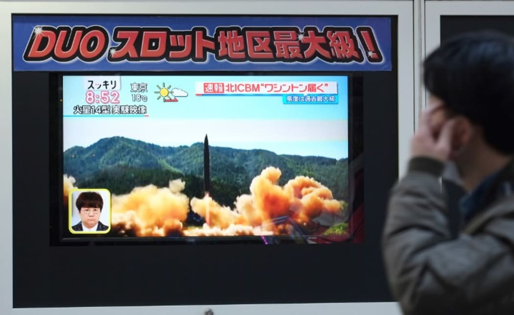 A pedestrian walks in front of a television screen displaying file news footage of a North Korean missile launch, in Tokyo, on Wednesday.