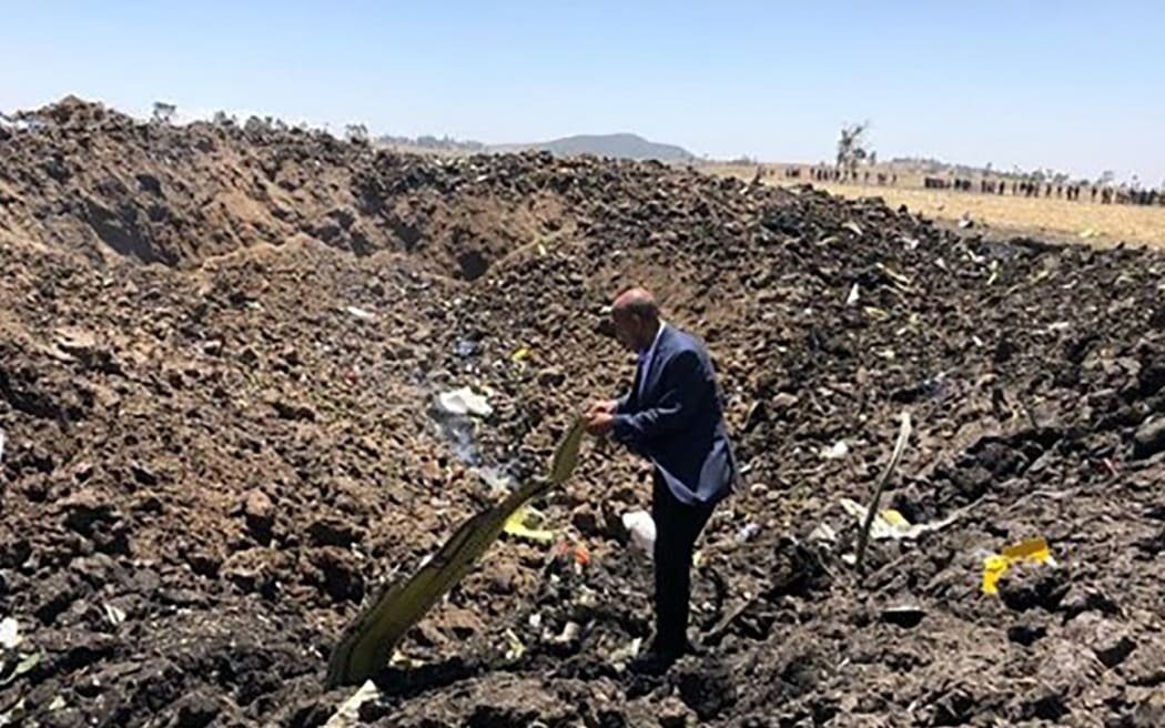 A man inspecting what is believed to be wreckage at the crash site of an Ethiopia Airlines aircraft near Bishoftu, a town some 60km southeast of Addis Ababa, Ethiopia.
