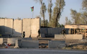 Afghan security personel stand guard near the airport complex in Kandahar on December 9, 2015.