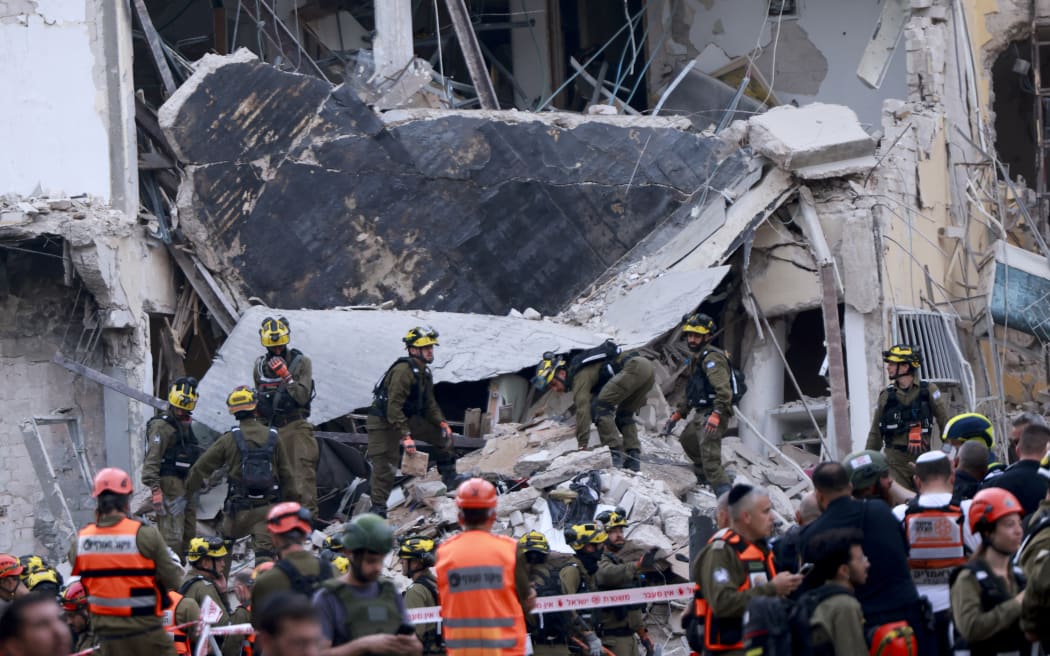 Rescuers sift through the debris of a damaged building in the Israeli city of Tel Aviv after a fresh barrage of Iranian rockets on 16 June, 2025.