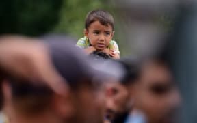 A young migrant boy sits on his father's shoulders at the Hungarian-Austrian border in Heiligenkreuz, Austria.