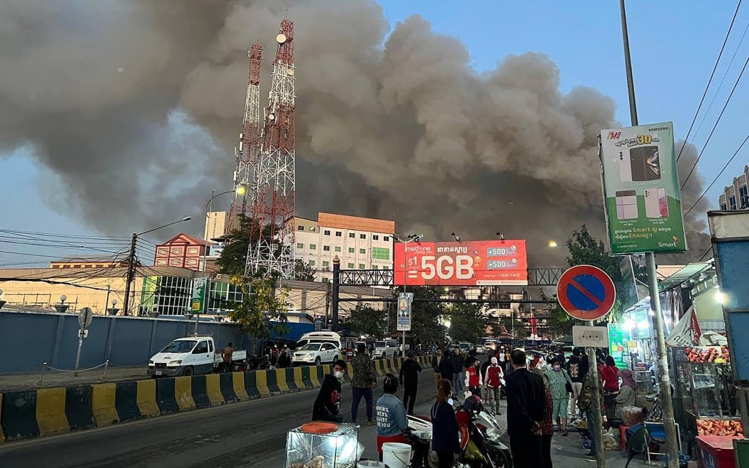 Smoke rises from a fire at the Grand Diamond City hotel-casino in Poipet on December 29, 2022.