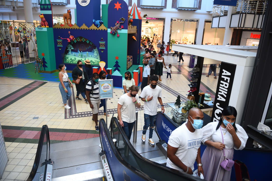 People wearing masks walk at a shopping mall as they continue their daily life amid Covid-19 in Cape Town, South Africa on December 27, 2020.