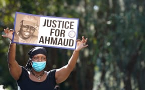 BRUNSWICK, GA - OCTOBER 18: Beverly Green, with the Transformative Justice Coalition, demonstrates at the Glynn County Courthouse as jury selection begins for the trial of the shooting death of Ahmaud Arbery on October 18, 2021 in Brunswick, Georgia.