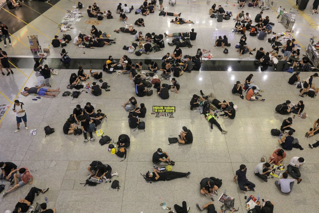 Protesters sit on the floor of the arrivals hall of Hong Kong's international airport.