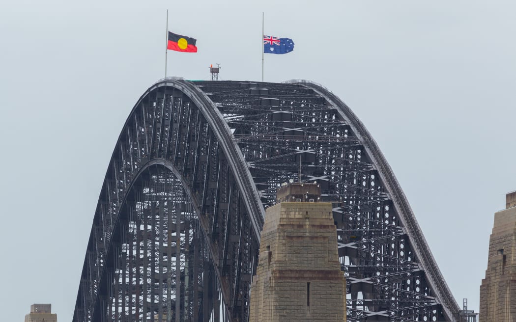 The Australian and Aboriginal flags fly at half-mast on the Harbour Bridge in Sydney on September 9, 2022. (Photo by Robert WALLACE / AFP)