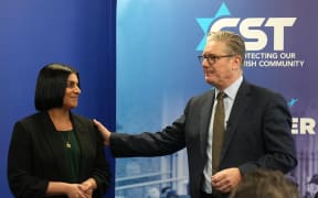 Britain's Home Secretary Shabana Mahmood (L) and Britain's Prime Minister Keir Starmer react as they speak to members of the Jewish community at the Community Security Trust (CST) in north west London on October 16, 2025, where they discussed the Government's response to the attack at the Heaton Park synagogue in Manchester. (Photo by CARLOS JASSO / POOL / AFP)