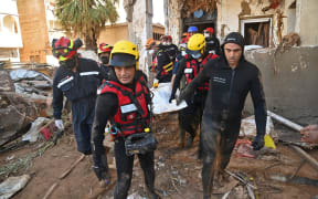 Emergency teams recover a body from a flood-damaged area in the Libyan city of Derna on 15 September.