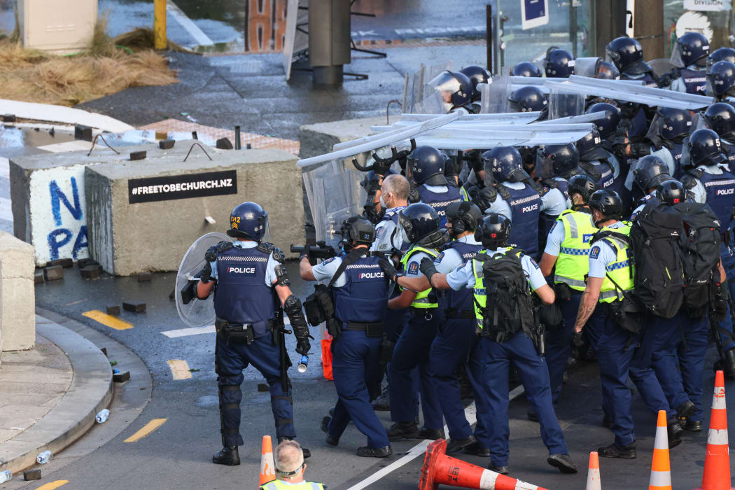 Police advance with the assistance of beanbag shotguns