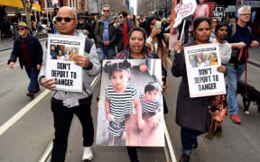 Protesters holds up placards in Melbourne on September 1 during a rally in support of a Tamil refugee family of four -- including two Australian-born toddlers -- who have been moved to the remote Australian detention centre on Christmas Island.