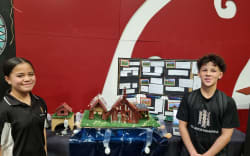 Meremia and Ezra from Te Rangihakahaka Wakanoa and their model of a marae built to rise from floodwaters