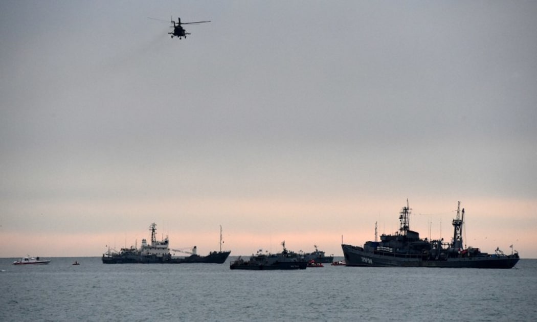 An helicopter flies over rescue vessels searching the Black Sea outside Sochi after a Russian military plane crashed.