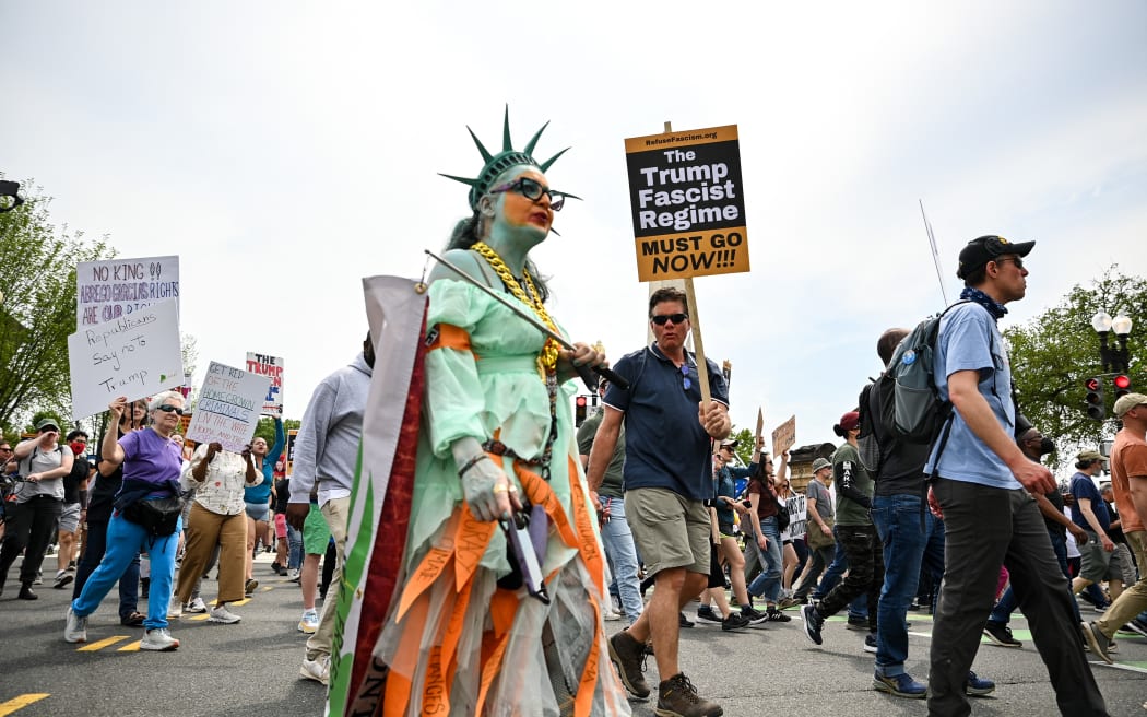 Protestors hold signs as they march towards the White House during a Free Kilmar Abrego and an Anti-Trump protest, in Washington, DC, April 19, 2025. Abrego Garcia was detained in Maryland last month and expelled to El Salvador along with 238 Venezuelans and 22 fellow Salvadorans who were deported shortly after President Donald Trump invoked a rarely-used wartime authority. 
Trump administration officials have claimed he is an illegal migrant, a gang member and involved in human trafficking, without providing evidence. 
A federal judge has since ordered he be returned, later backed up by the Supreme Court.
But the administration -- despite admitting an "administrative error" in his deportation -- contends he is now solely in Salvadoran custody. (Photo by Richard PIERRIN / AFP)