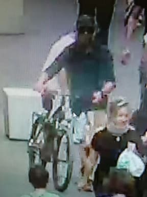 This handout video frame grab from a surveillance. Police are hunting a man believed to be in his early 30s on a mountain bicycle who witnesses and security cameras saw in the area immediately before the explosion.