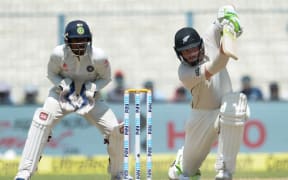 New Zealand's Martin Guptill (R) plays a shot as India's wicketkeeper Wriddhiman Saha looks on during the fourth day of the second Test match between India and New Zealand at The Eden Gardens Cricket Stadium in Kolkata on October 3, 2016. -