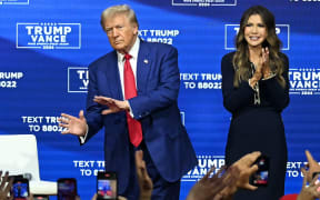 Former US President and Republican presidential candidate Donald Trump, with moderator and South Dakota Governor Kristi Noem (R), arrives for a town hall at the Greater Philadelphia Expo Center and Fairgrounds in Oaks, Pennsylvania, on October 14, 2024. (Photo by Jim WATSON / AFP)