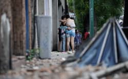 People remain on a street following an earthquake in Caracas on June 24, 2026. A magnitude 7.1 earthquake struck Venezuela on Wednesday, the United States Geological Survey (USGS) reported, triggering panic in Caracas, according to AFP journalists. The tremor, which was followed by several aftershocks, was also felt in Colombia. (Photo by Manaure Quintero / AFP)