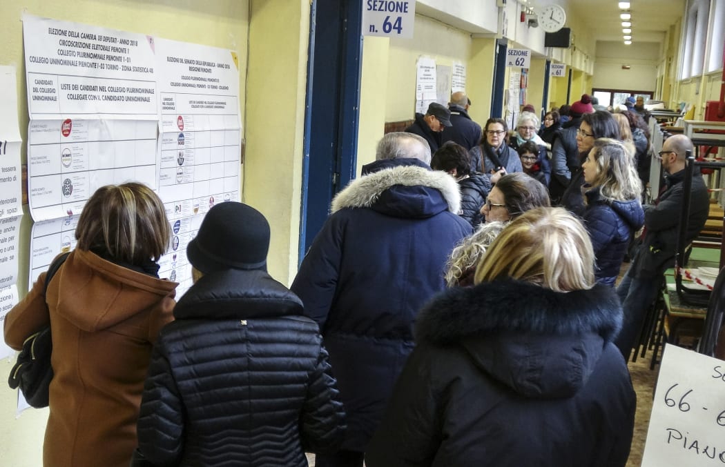 People line up to vote for general elections on March 4, 2018 at a polling station in Turin.