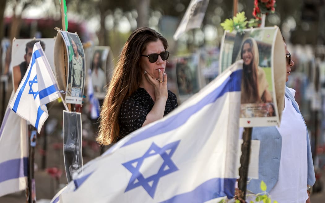 A woman reacts while visiting a memorial for the victims killed at or kidnapped from the Supernova music festival during the October 7 attacks by Palestinian militants, at the festival site near Kibbutz Reim in southern Israel, on the eve of the attacks' first anniversary on October 6, 2024. (Photo by Menahem Kahana / AFP)