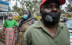 People wear face masks while queueing during a mass testing for Covid-19. File photo.