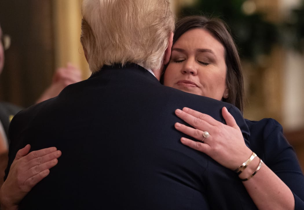 Outgoing White House Press Secretary Sarah Huckabee Sanders hugs US President Donald Trump after the announcement of her departure.