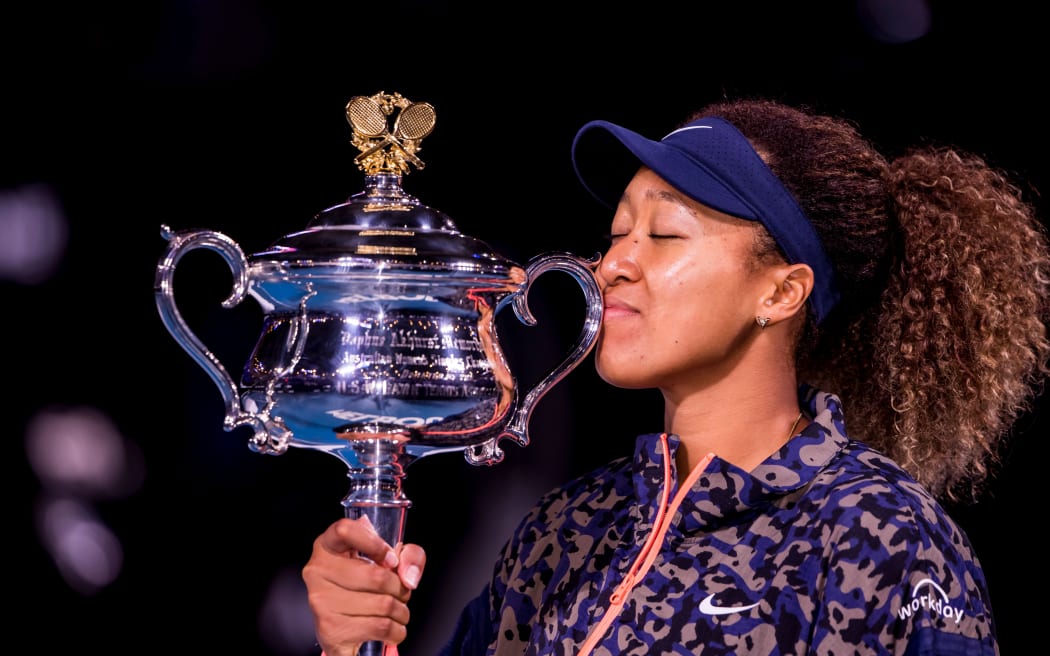 Naomi Osaka of Japan kisses her trophy after winning the Women's Singles Final of the 2021 Australian Open.