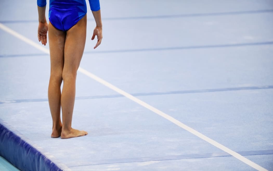 Feet of gymnast are seen on the floor exercise before gymnastics competition